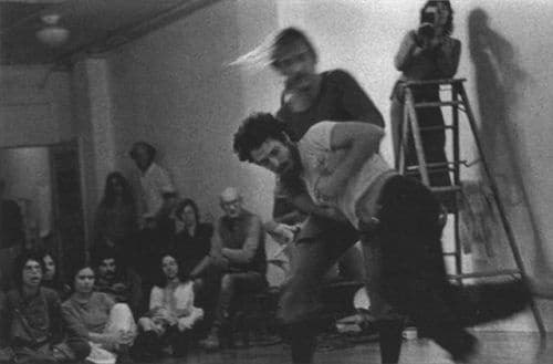Стив Пэкстон (впереди) и Курт Сиддалл танцуют, Лиза Нельсон снимает на видео (на лестнице). Первый перформанс серии Reunion, январь 1975 г., Natural Dance Studio, Окленд, Калифорния